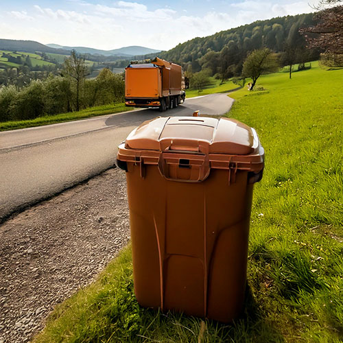 Biotonne am Straßenrand vor grüner Hügellandschaft – Abfuhr durch die AVL Ludwigsburg im Landkreis Ludwigsburg im Rahmen der nachhaltigen Abfallverwertung und Abfallvermeidung